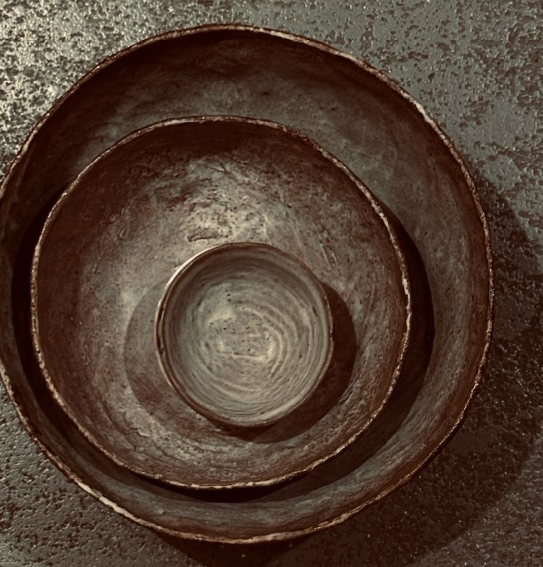 Nested stoneware bowls by Kasia Białek in earthen, rusty tones